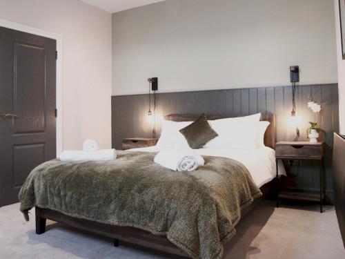 a bedroom with a large bed with white pillows at Apartment 1 Old Conservative Club in Historic Town Pass the Keys in Caernarfon