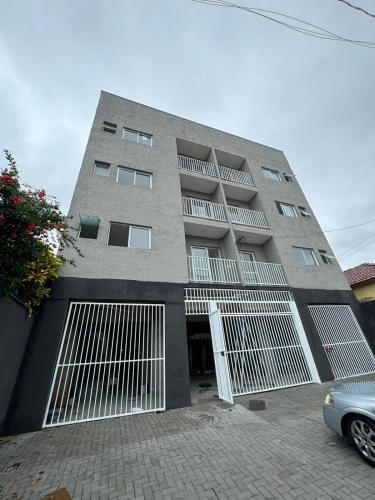 a building with white doors and a car parked in front at Flat Braganca in Bragança Paulista