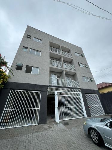 a gray building with a car parked in front of it at Flat Braganca in Bragança Paulista