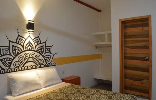 1 dormitorio con 1 cama de diseño en blanco y negro en la pared en Hotel Axolotl en Puerto Escondido