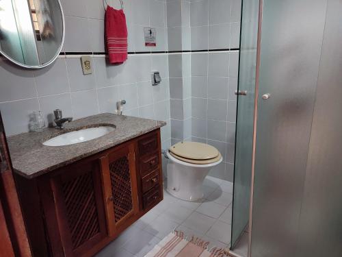 y baño con aseo, lavabo y espejo. en Pousada Ancore en São Sebastião