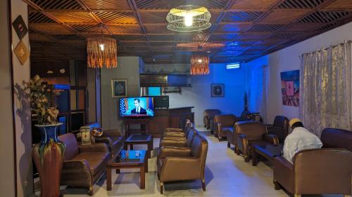 una sala d'attesa con un mucchio di sedie e una TV di HOTEL ALIA a Gibuti