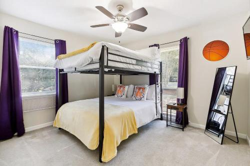 a bedroom with a bunk bed with a ceiling fan at LSU Slammer Arcade 4 5 mile to LSU Private Yard in Baton Rouge