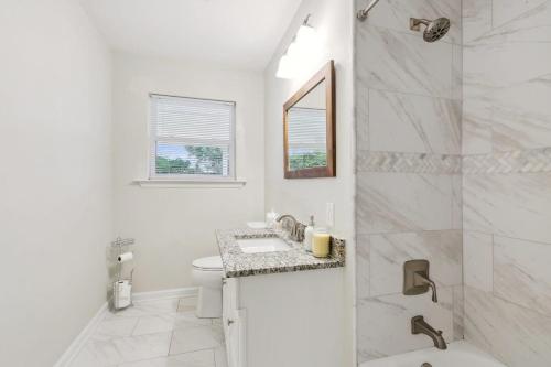 biała łazienka z umywalką i prysznicem w obiekcie LSU Slammer Arcade 4 5 mile to LSU Private Yard w mieście Baton Rouge