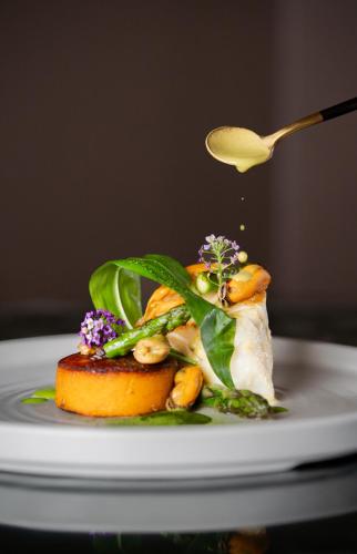 a spoonful of food on a plate with vegetables at The King Of Prussia in Fowey