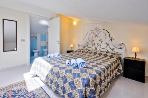 a bedroom with a large bed with two rolls at Greenfish House, Fertilia near the beach in Fertilia
