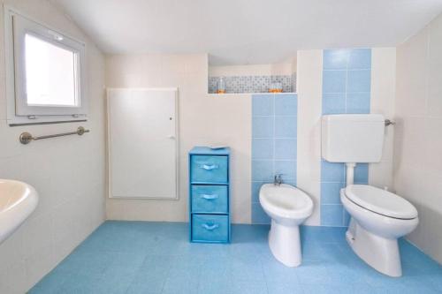 a blue and white bathroom with a toilet and a sink at Greenfish House, Fertilia near the beach in Fertilia