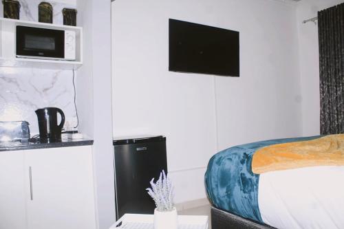 a bedroom with a bed and a microwave on the wall at Contemporary Gem: Studio with Serene Pool View in Newcastle