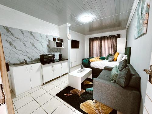 a small room with a bed and a couch in it at Contemporary Gem: Studio with Serene Pool View in Newcastle