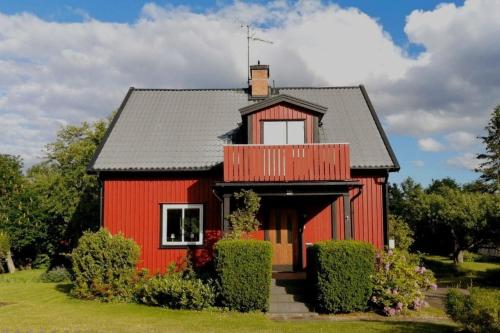ein rotes Haus mit schwarzem Dach in der Unterkunft Buntes Schwedenhaus Lillebror in Fågelfors