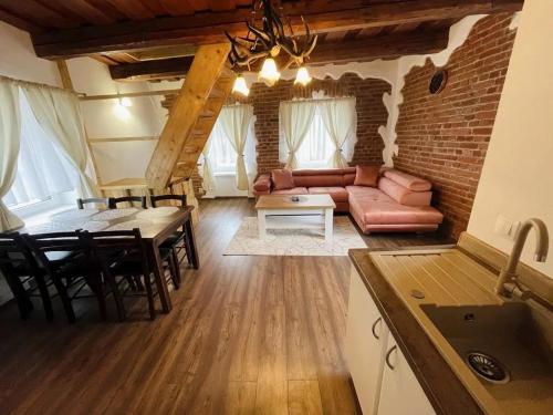 een woonkamer met een bank en een tafel bij Apartmán Trícia-Ebiky-Jedlo a Pit-Centrum in Heľpa