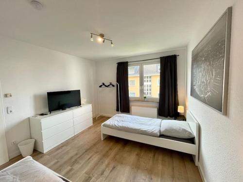 ケーニヒスヴィンターにあるCharmantes Apartment mit 3 Bettenのベッドと薄型テレビのある寝室