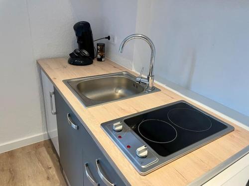 ケーニヒスヴィンターにあるCharmantes Apartment mit 3 Bettenのキッチン(シンク、コンロ付)