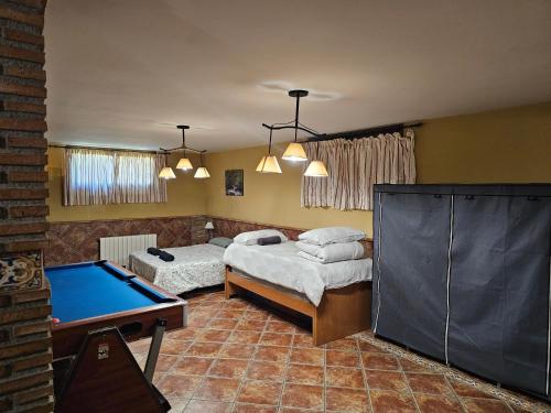 a room with two beds and a pool table at Apto-en el Bajo de la casa-estilo rústico en Dílar in Dílar
