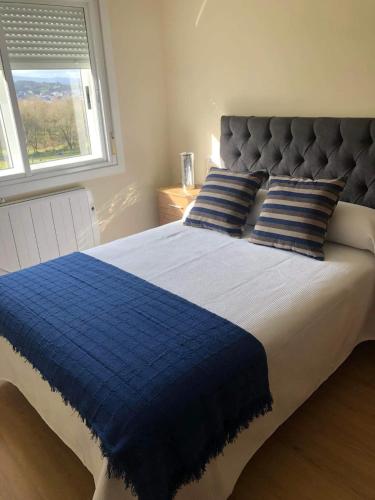 Armeses的住宿－Casa Aricel，蓝色和白色的床、蓝色枕头和窗户