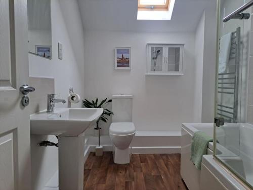y baño con lavabo, aseo y bañera. en Vibrant Coastal Village Retreat- private parking en Lympstone