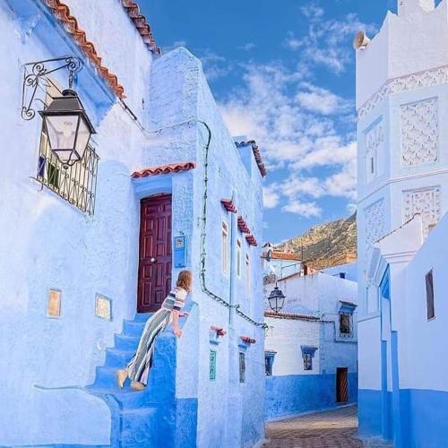 a painting of a child sitting on the side of a building at Casa Plasa Grande CHAOUEN in Chefchaouene