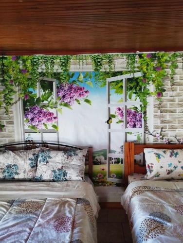 ein Schlafzimmer mit 2 Betten und Blumen an der Wand in der Unterkunft Marios House 2 in Xánthi