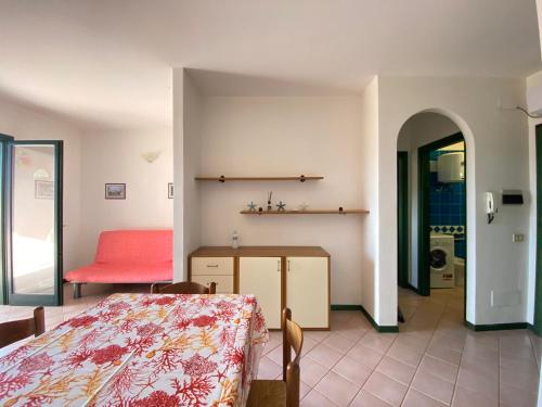 a bedroom with a bed and a table in a room at Appartamento in complesso con piscina in Santa Teresa Gallura