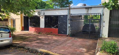 a house with a gate and a car parked outside at Clotilde Depto Completo in Posadas