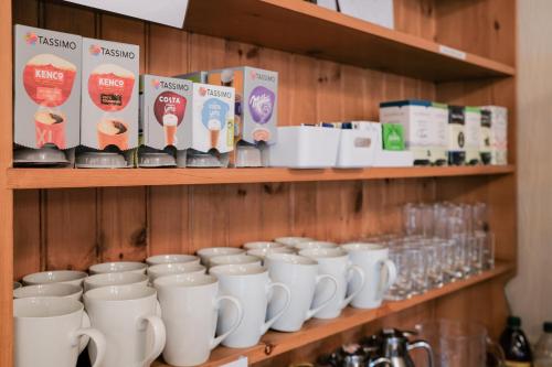 a row of white mugs sitting on a shelf at The Kildare in Skegness