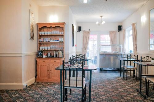 a room with tables and chairs and a book shelf at The Kildare in Skegness