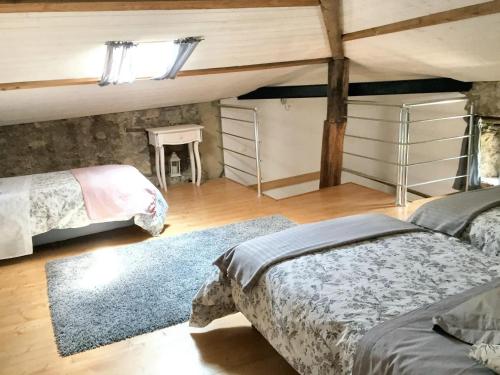 Schlafzimmer im Dachgeschoss mit 2 Betten und einem Teppich in der Unterkunft Maison de 5 chambres avec piscine partagee jardin clos et wifi a Saint Andre de Cruzieres in Saint-André-de-Cruzières
