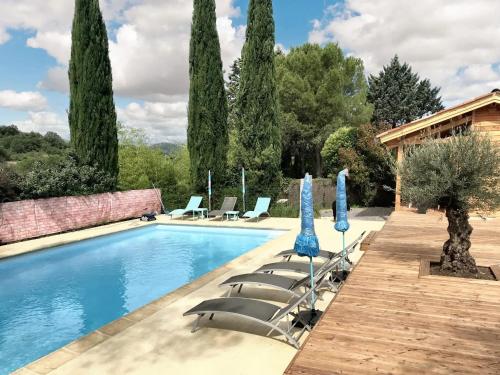 einen Pool mit Liegestühlen und Sonnenschirmen in der Unterkunft Maison de 5 chambres avec piscine partagee jardin clos et wifi a Saint Andre de Cruzieres in Saint-André-de-Cruzières