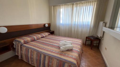 a hotel room with a bed with two towels on it at Hostal del Sol in San Bernardo