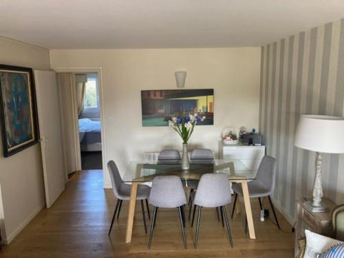 een eetkamer met een glazen tafel en stoelen bij TOP central Cabourg 2Terrasses 80m2 in Cabourg