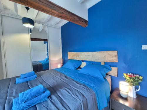 - une chambre bleue dotée d'un lit avec des draps bleus dans l'établissement Maison de campagne dans un village de caractère, à Saint-Galmier