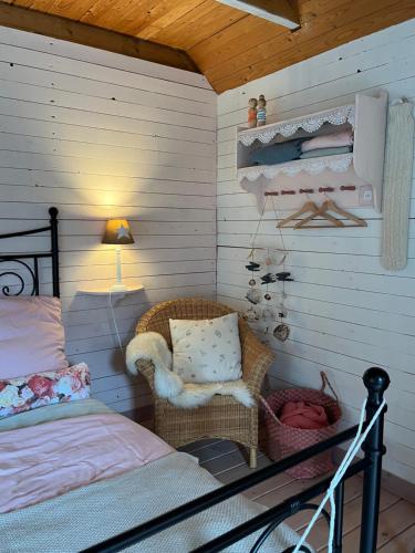 a bedroom with a bed and a chair and a lamp at Gartenzimmer zwischen den Meeren in Ladelund
