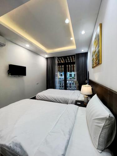a hotel room with two beds and a television at Legacy Hotel - Grand World Phú Quốc in Phu Quoc