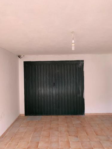 a green garage door in a white room with a tile floor at Il Marinaio in Messina