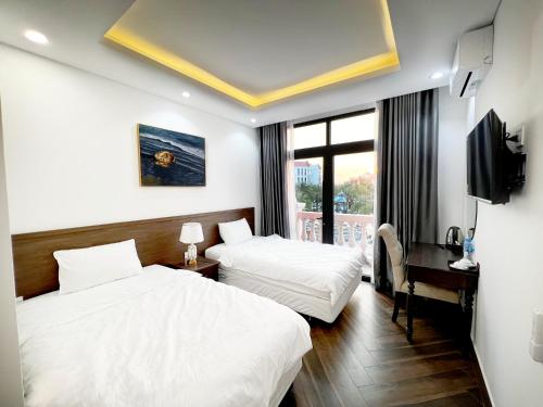 una camera d'albergo con due letti e una televisione di Legacy Phú Quốc a Phu Quoc