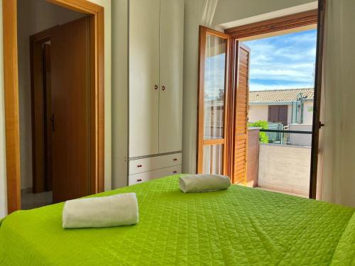 1 dormitorio con cama verde y ventana grande en New Residence, en Buonfornello