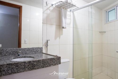 a bathroom with a sink and a glass shower at Blue Sunset in João Pessoa