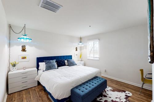 a bedroom with a large bed with a blue bench at Nash-Vegas Oasis in Nashville