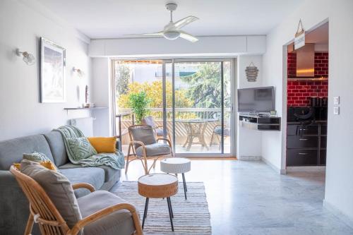 un salon avec un canapé et des chaises dans l'établissement Rue d'Antibes Cannes Bright apartment with terrace, à Cannes