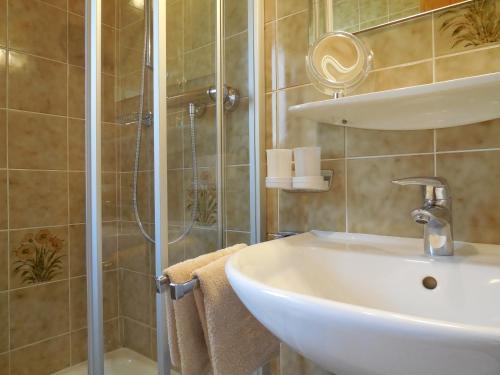 ein Bad mit einem Waschbecken und einer Dusche in der Unterkunft Haus Kurz Matthäus in Walchsee