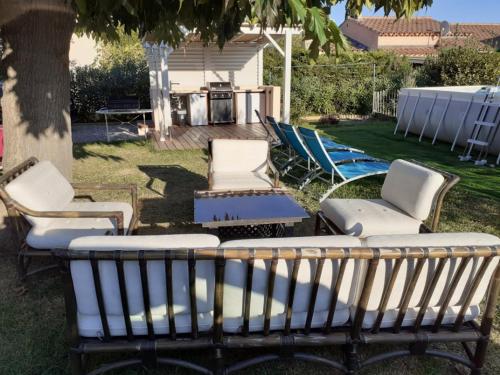 un groupe de chaises, une table et un groupe de chaises dans l'établissement Haut de villa avec jardin (Apt T3), à Bormes-les-Mimosas