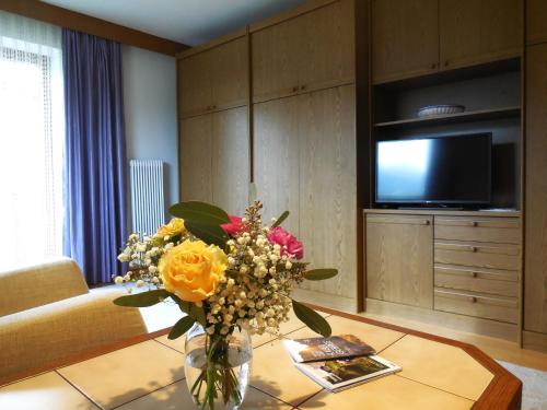 a vase of flowers on a table in a living room at Haus Kurz Matthäus in Walchsee