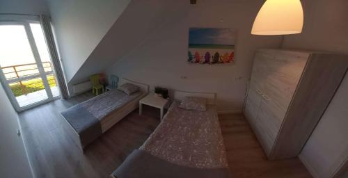 um pequeno quarto com 2 camas e uma janela em Apartament Pogodny em Leba