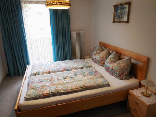 Schlafzimmer mit einem Bett und einem Fenster mit blauen Vorhängen in der Unterkunft Haus Kurz Matthäus in Walchsee
