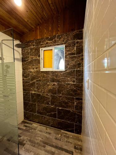 a bathroom with a glass shower and a window at Eco Hotel Valley View in SJM