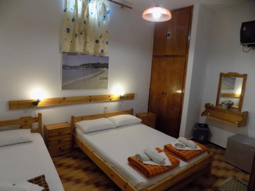 a bedroom with two beds and a mirror at PensionMargaritaKotroniSkiathos in Skiathos Town
