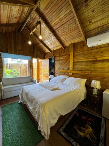 SJMにあるEco Hotel Valley Viewの木製の部屋に大型ベッドが備わるベッドルーム1室が備わります。
