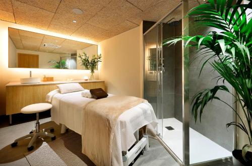 um quarto de hospital com uma cama e um chuveiro em Hesperia Barcelona Sant Just em Sant Just Desvern