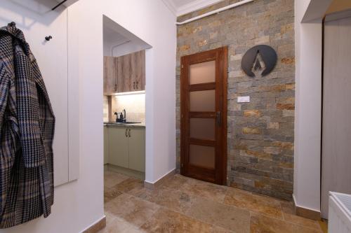 a hallway with a brick wall and a door at Várvédőház Apartmanok Eger in Eger