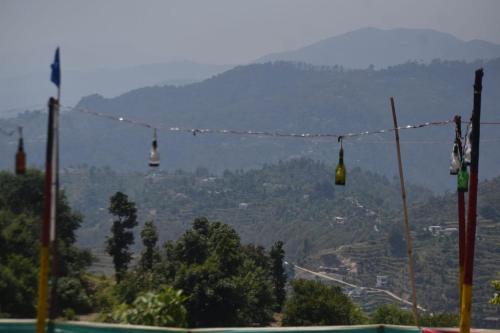 a group of bells hanging on a string with a mountain at Camp Moonlight beauty in Nainital